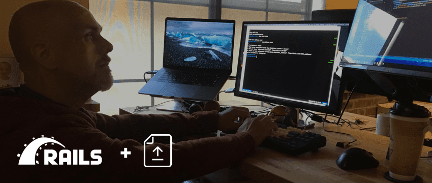 Blog header with a software engineer looking at multiple computer screens with lines of code. There is an overlay of icons: the Rails logo, a plus sign, and an icon for upload.